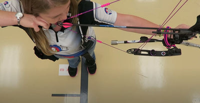 Overhead view of Coach Heather Pfeil aiming her compound bow.