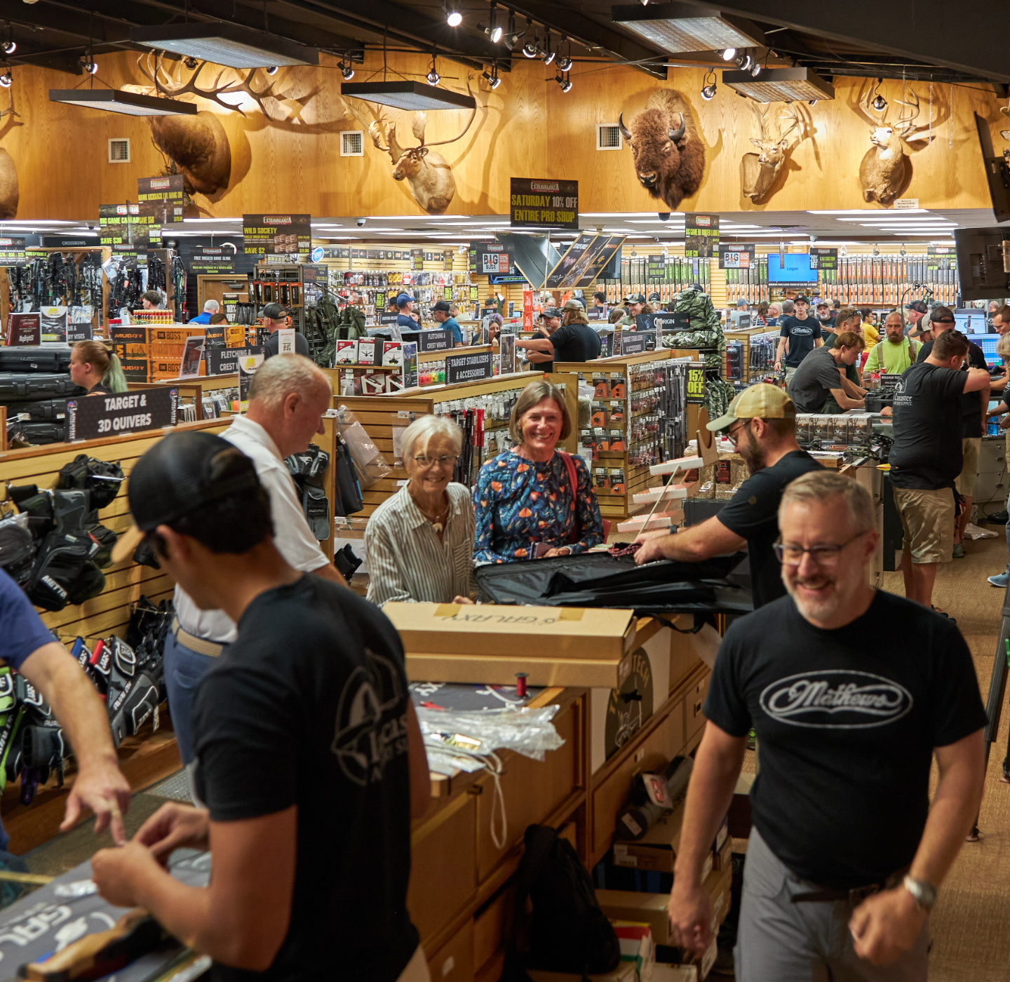 Man holding sign asking you to sign into the qminder Lancaster Archery Supply Pro Shop