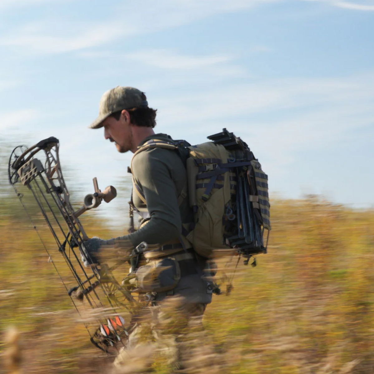 archer wearing a latitude pack with climbing sticks and a Mathews Lift compound bow.