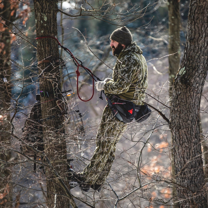 Bowhunter wearing camo in a Trophyline tree saddle.