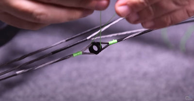 P.J. Reilly ties a center string on his peep with green serving holding the peep on his bowstring. 