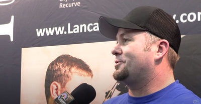 Reo Wilde speaks into Lancaster Archery microphone at the ATA Show.