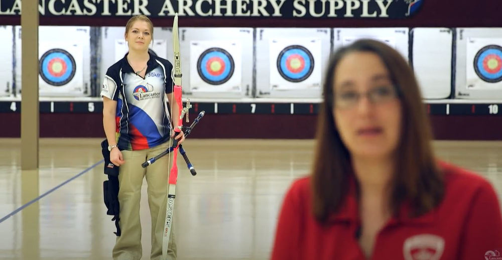 Coach Heather Pfeil wearing a Lancaster Archery Supply jersey inside an archery range.