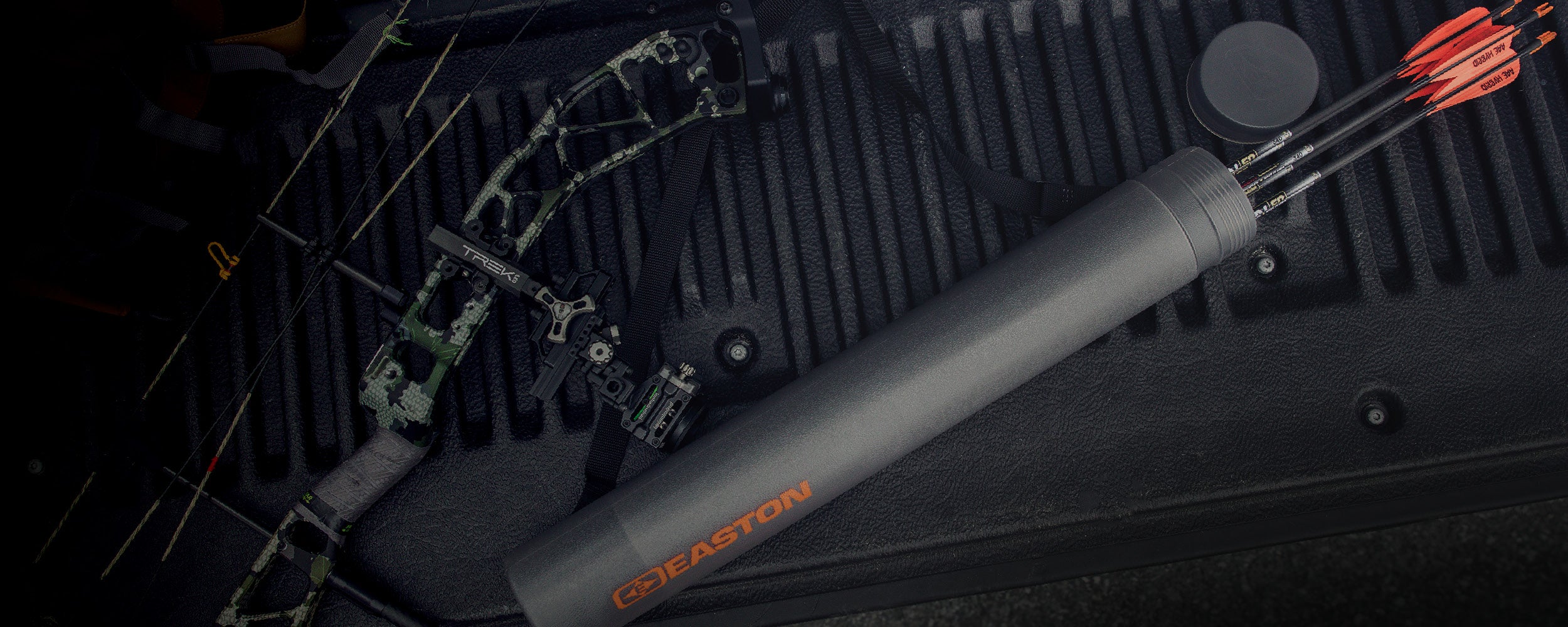 Gray bow sight on a black background with archery equipment.