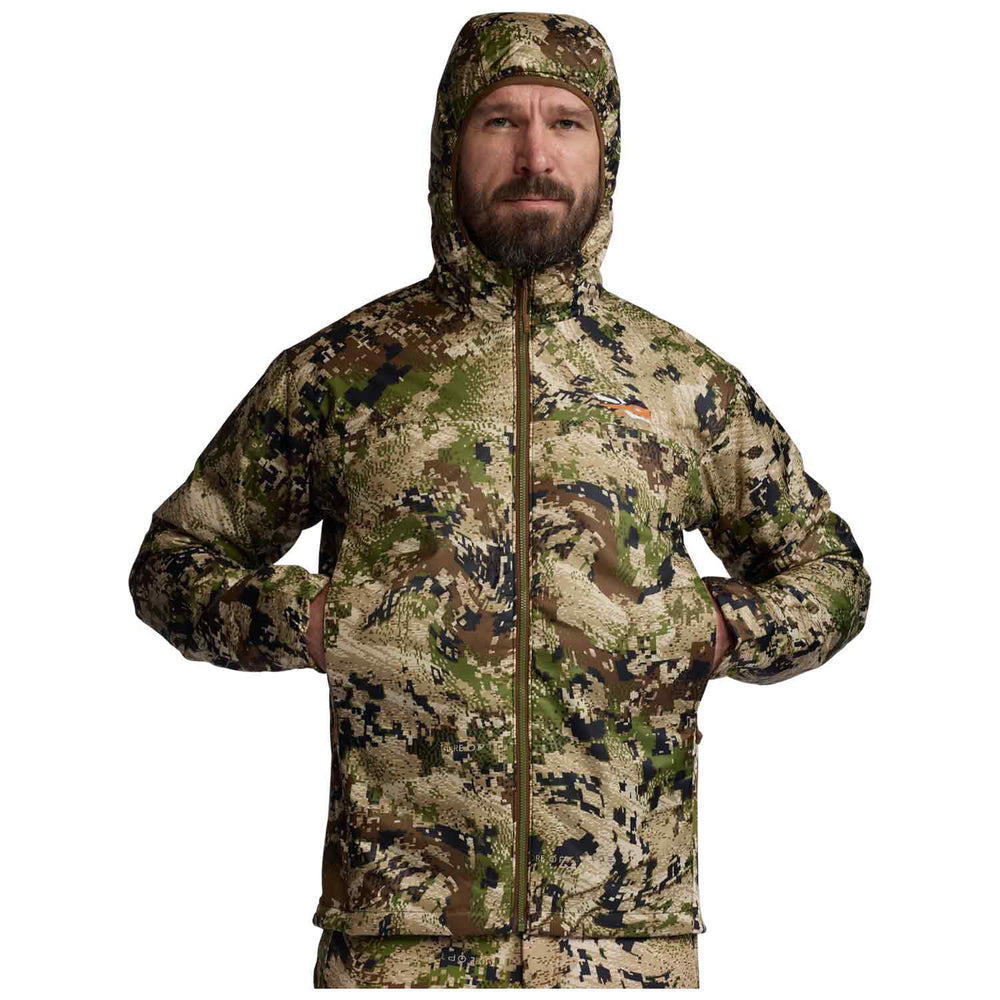 A man wearing a hooded camouflage jacket with a full front zipper, photographed against a plain white background.