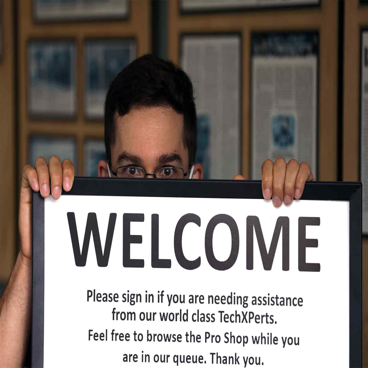 Man holding sign asking you to sign into the qminder Lancaster Archery Supply Pro Shop