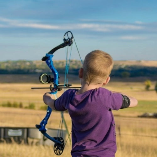 Child with a blue bow and arrow in an open field